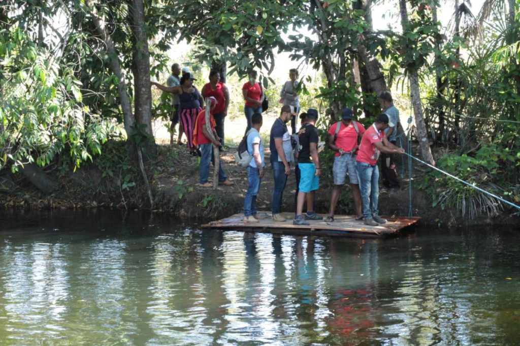 Quilombolas precisam atravessar rio para chegar à roça, onde cultivam mandioca, arroz e outros alimentos